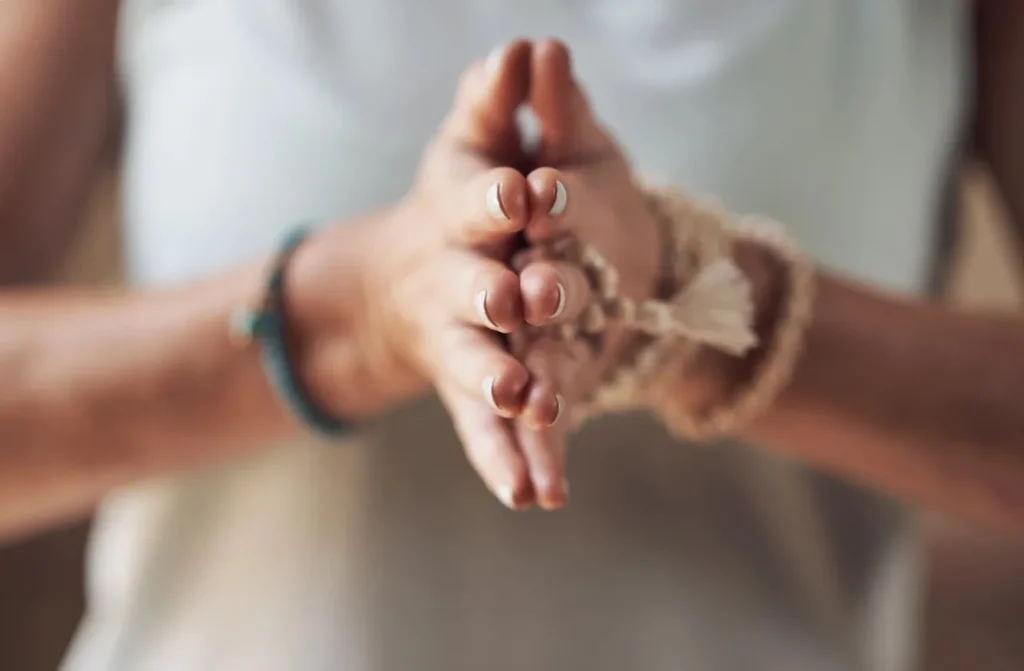 Close-up of hands clasped together in a prayer or meditation gesture