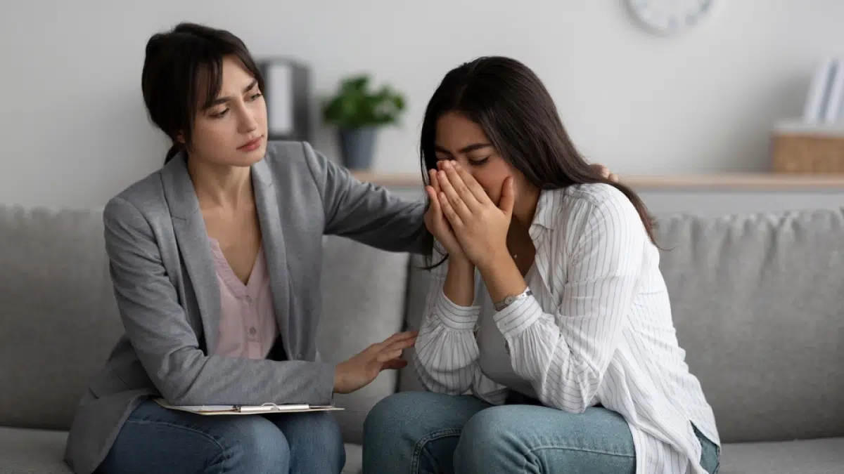 Therapist comforting a crying woman. PTSD can affect the immune system and potentially lead to substance abuse.