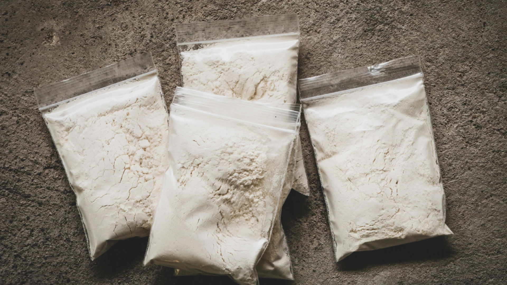 Bags of white powder stacked on top of each other.