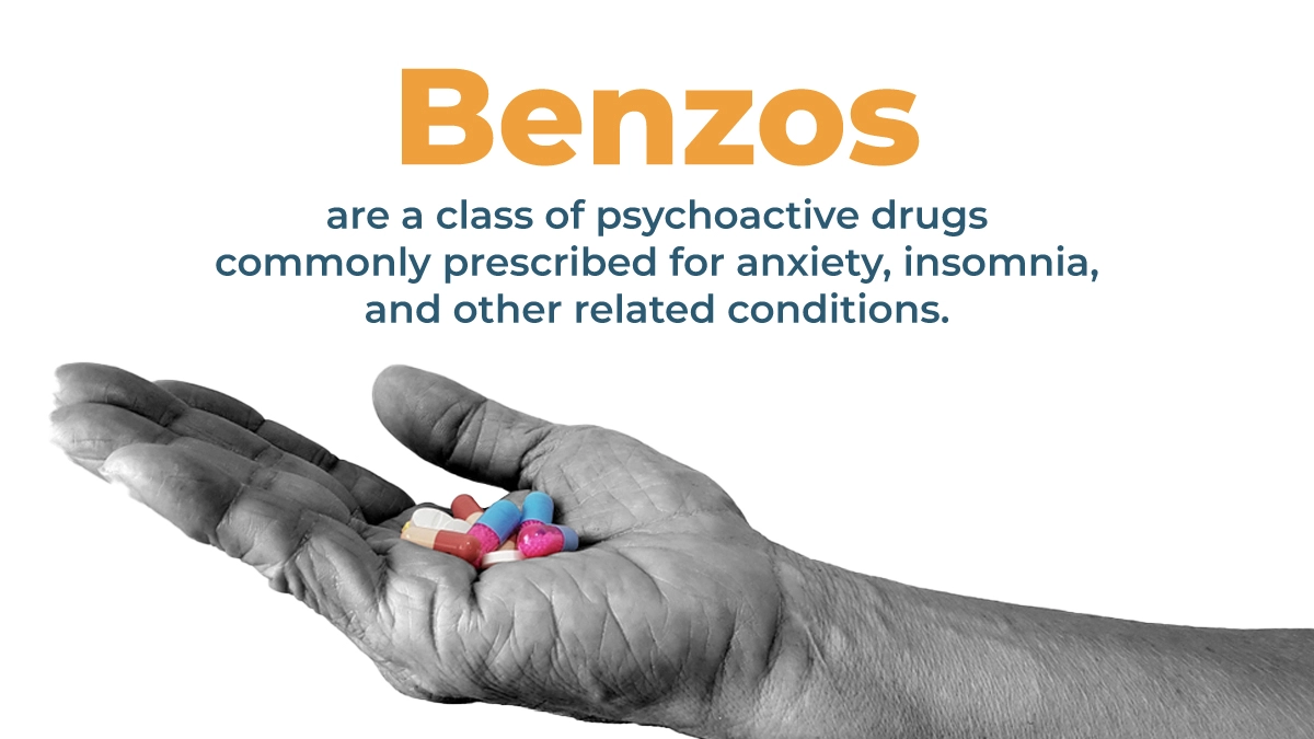 Hand in grayscale holding a stack of multicolored pills. Benzos are a class of psychoactive drugs commonly prescribed for anxiety.