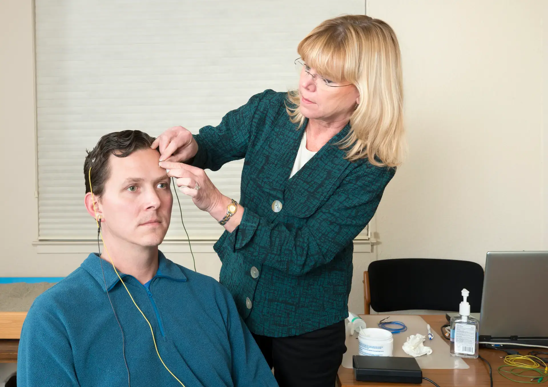 A nurse setting up equipment for biomedical feedback therapy