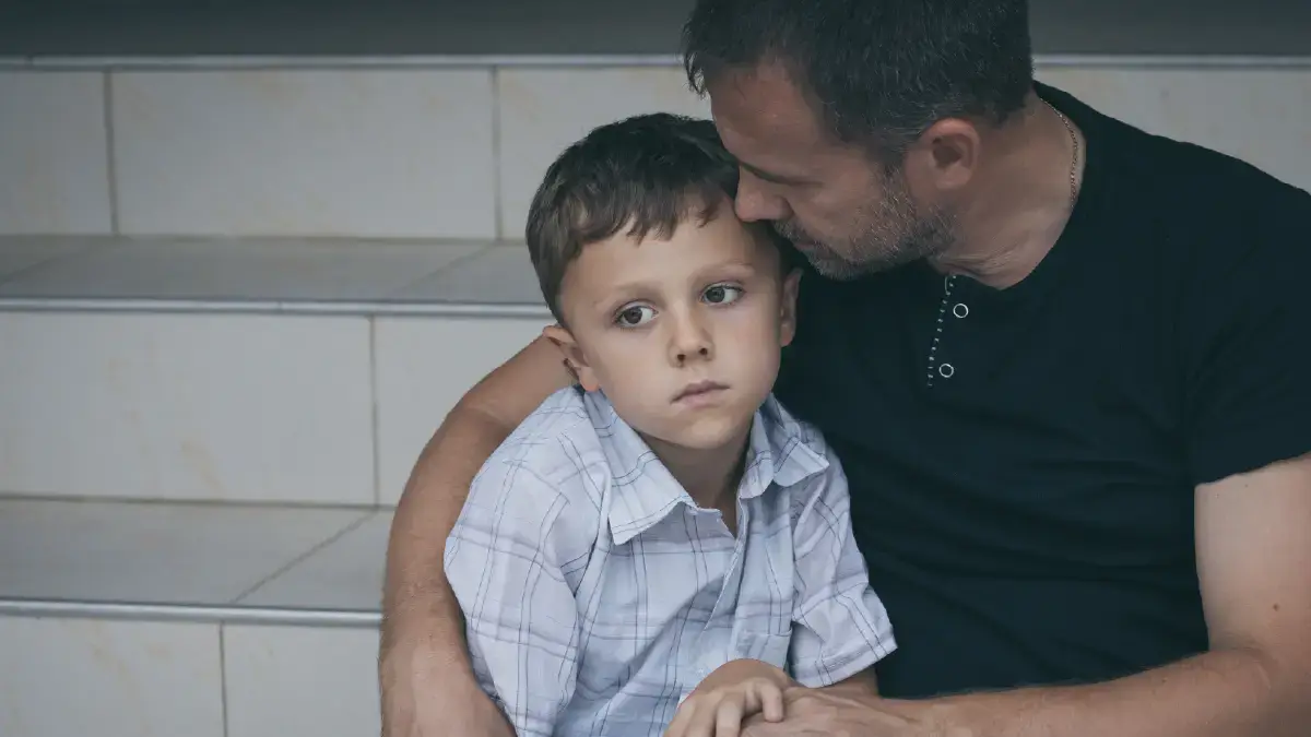 Image of a father comforting his saddened son