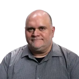 A portrait of a man with a shaved head and a gray shirt.