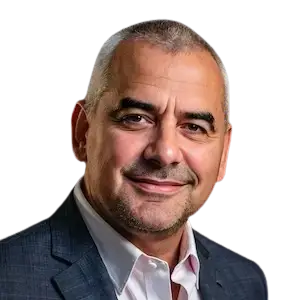 A headshot of a man with short, dark hair, wearing a dark suit jacket and a light-colored shirt, smiling slightly at the camera.