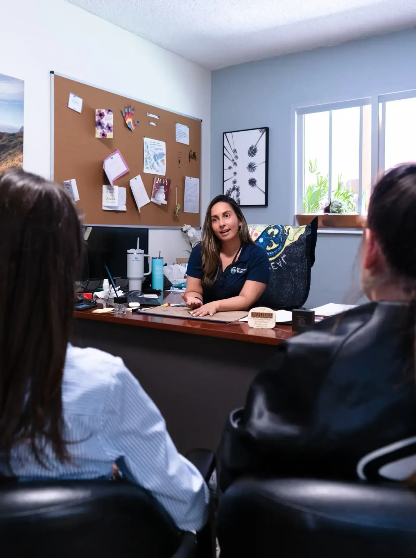 Recovery Team staff member meeting with clients in a private office at the Delray Beach treatment center.